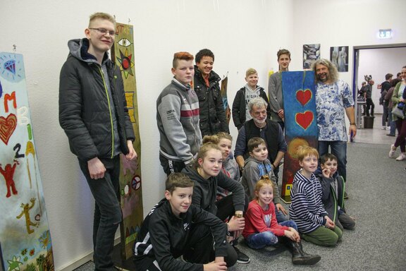 Gruppenbild während der Vernissage. In der Mitte Künstler Paul Berno Zwosta, rechts Friedenshort-Mitarbeiter Bernd Härtner.  