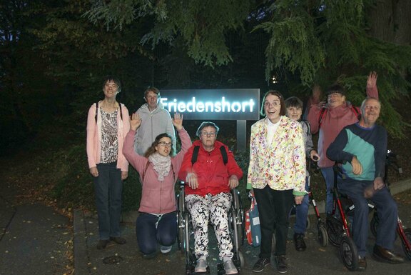 Ein Abendfoto vor dem leuchtenden Friedenshort-Schild Ein Abendfoto vor dem leuchtenden Friedenshort-Schild