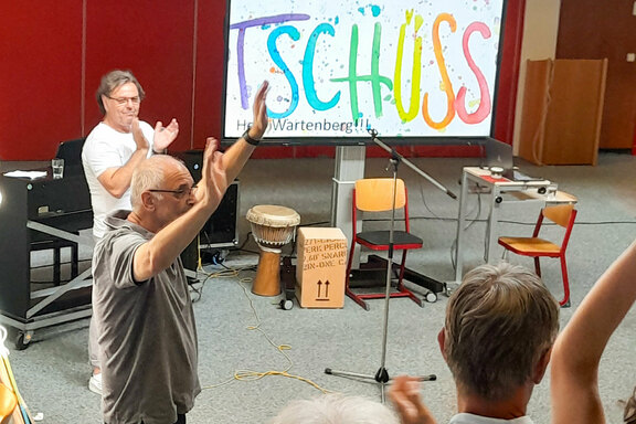 Jörg Wartenberg winkt mit beiden Händen  