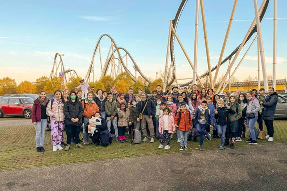 Gruppenfoto mit Achterbahn im Hintergrund