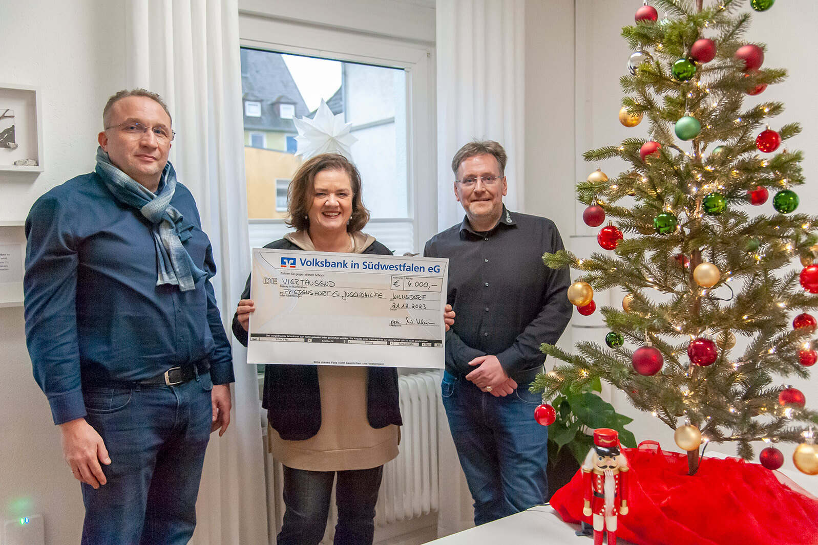 Firmenvertreter überreichen symbolischen Scheck