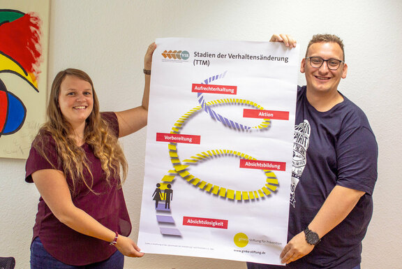 Sophie Richter und Rouven Gommers zeigen ein Plakat aus ihren Schulungsunterlagen