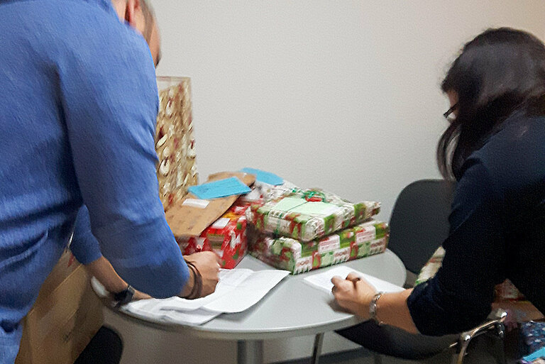 Die Friedenshort-Mitarbeiter Marco Haase und Tamara Michl ordnen die Geschenke ihren Empfängern zu